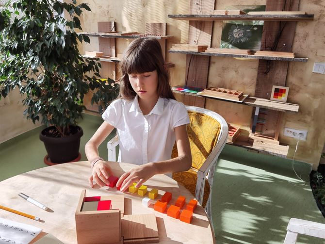 O fata de lucrand cu Materiale Montessori pentru copii de 6-12 ani la Montessori Cluj la Scoala Primara Montessori Cluj