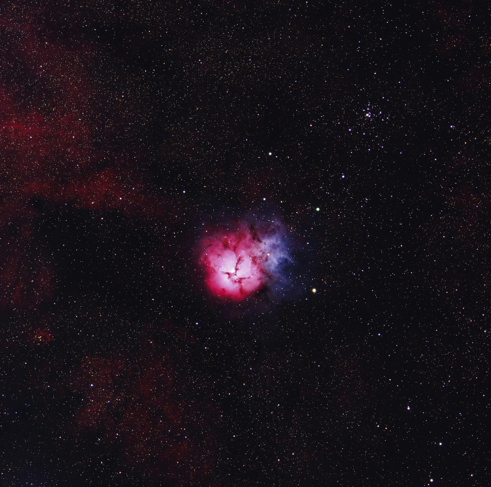 A pink and purple nebula in the night sky