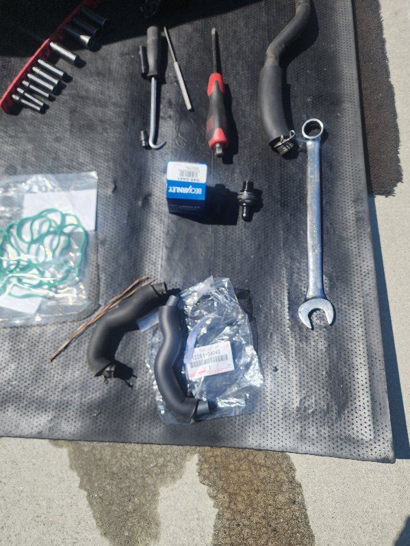 A bunch of tools including a wrench and a screwdriver on a mat