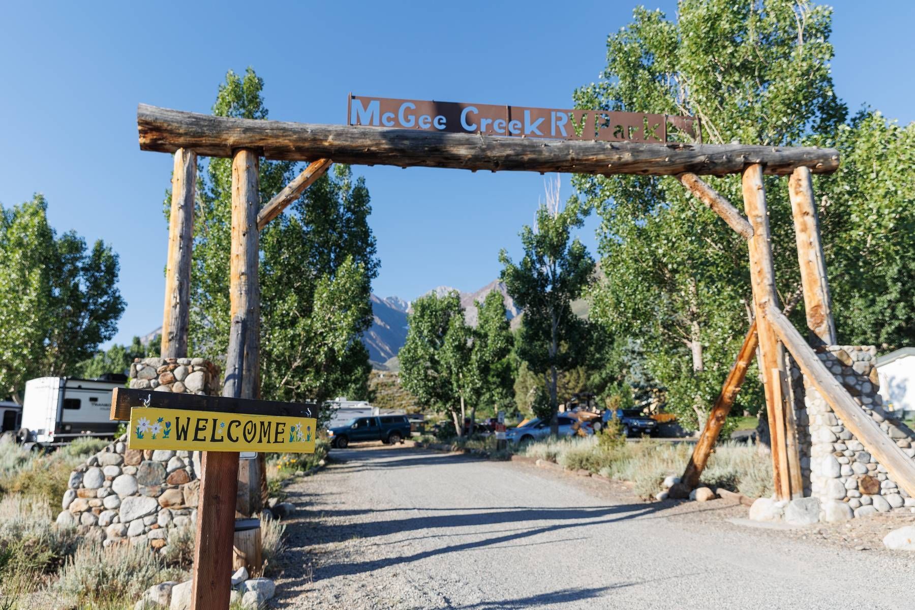 A wooden archway with a welcome sign on it