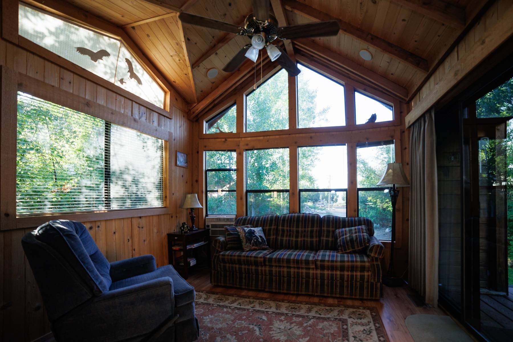 A living room with a couch a chair and a ceiling fan