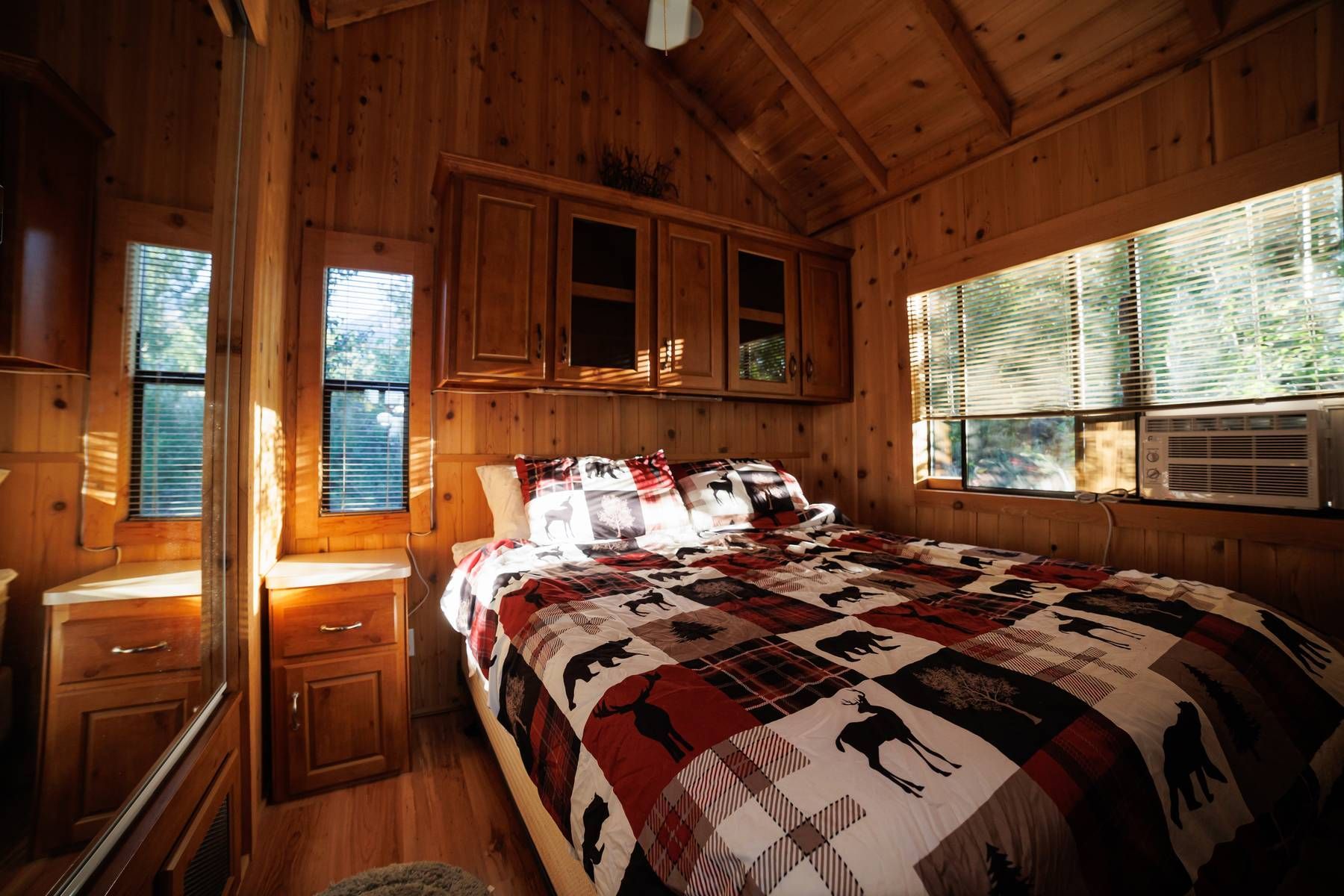 A bedroom in a cabin with a bed and a window