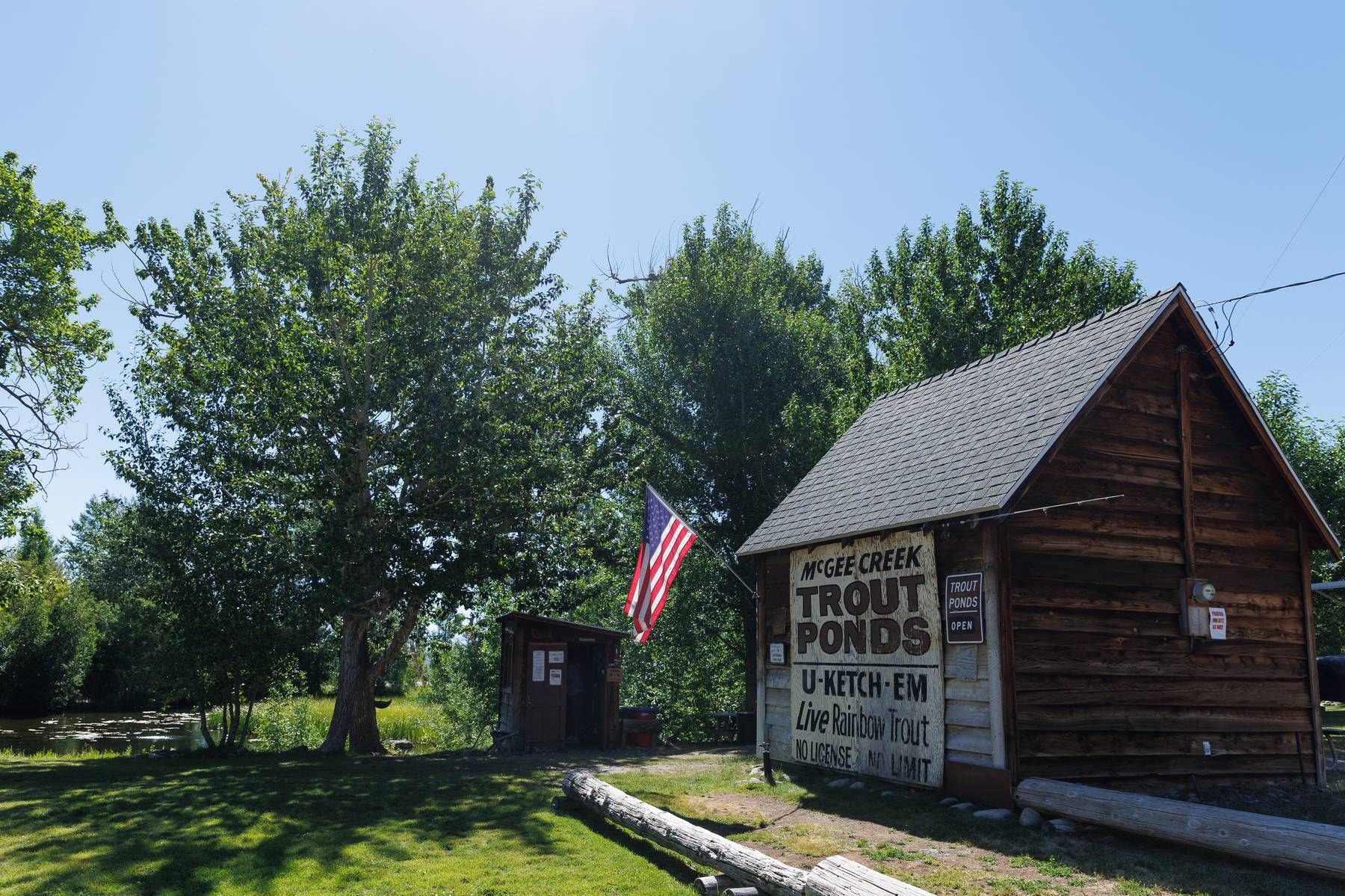 A small wooden building with a sign that says trout ponds