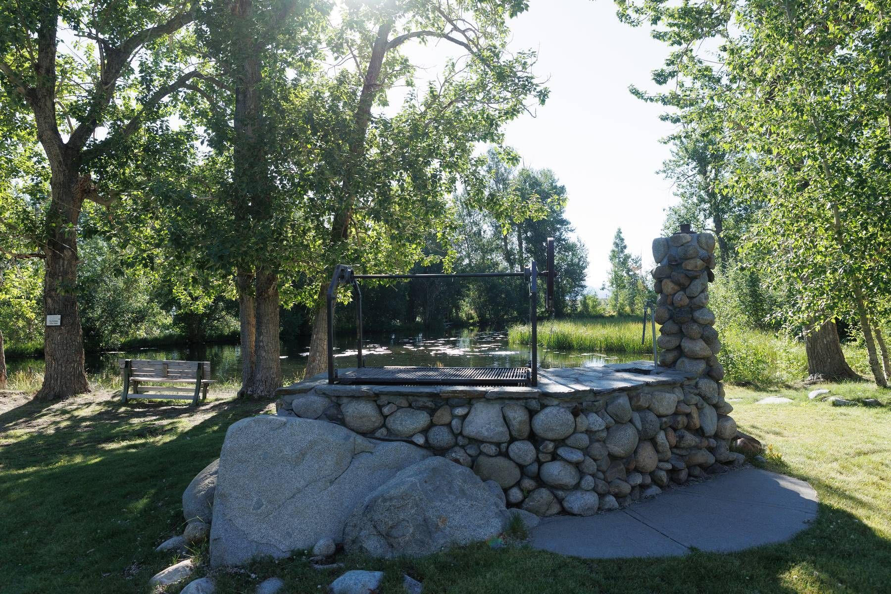 A stone wall in a park with trees in the background
