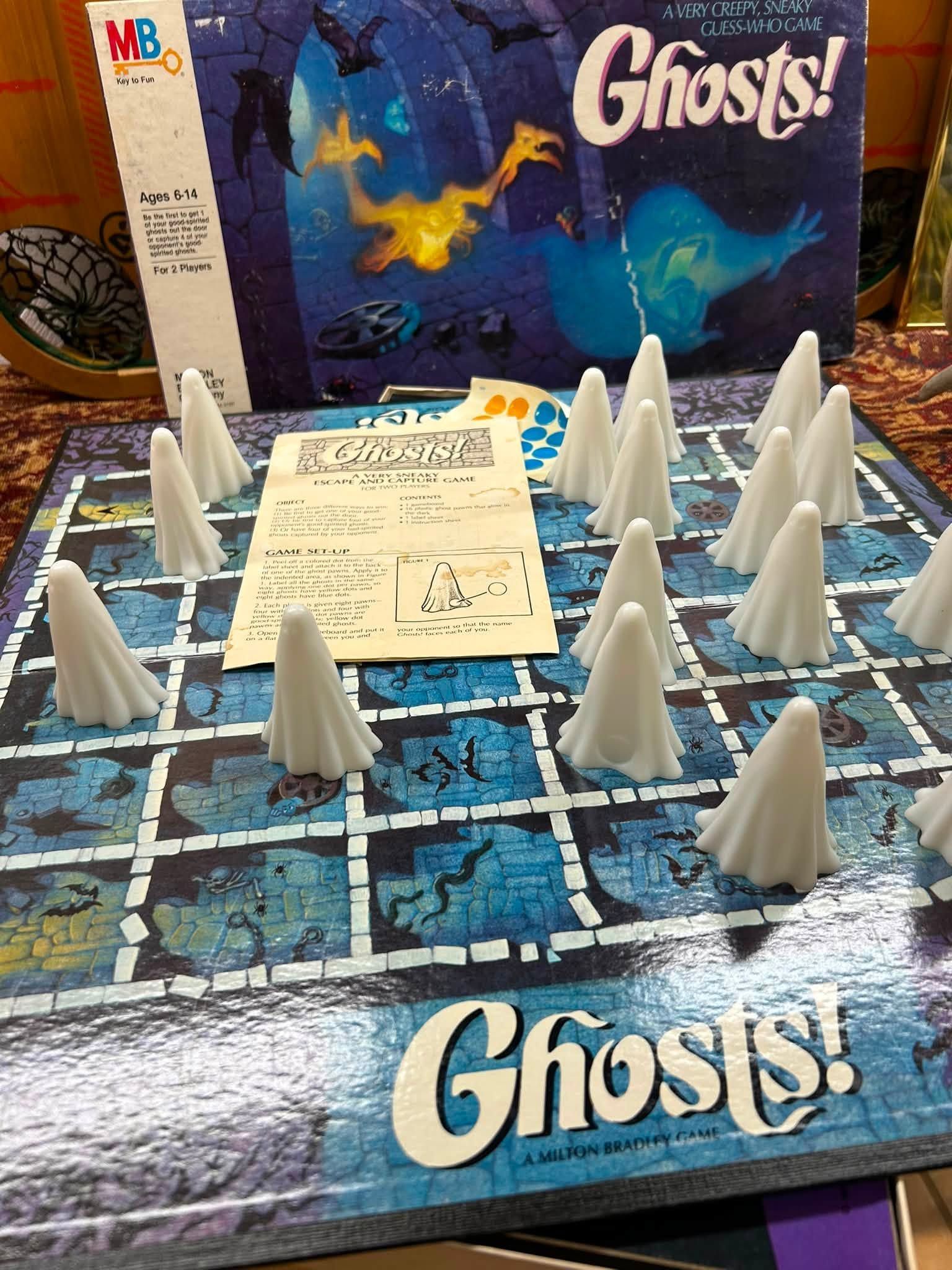 Ghosts! board game with white ghost pieces on a blue haunted-house board.