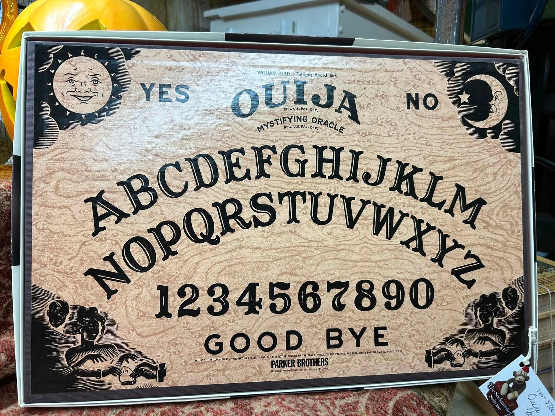 Ouija board with alphabet, numbers, “YES,” “NO,” and “GOOD BYE” on a worn beige surface