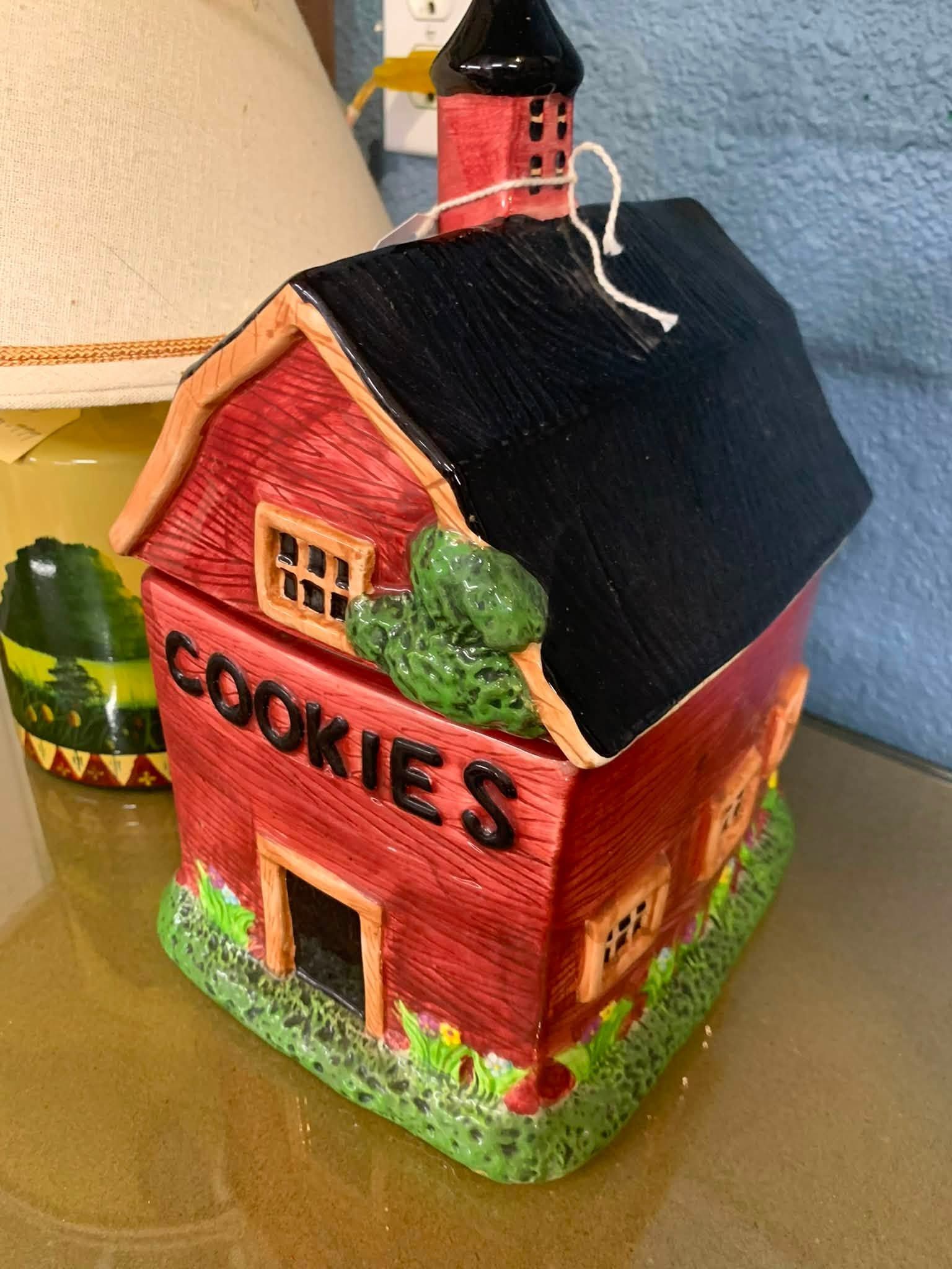 Red cookie house model with black roof and green trim, labeled “COOKIES” on the front