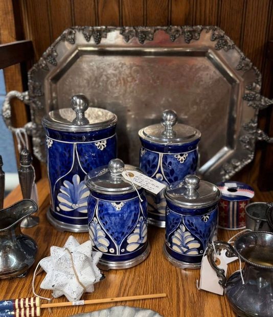 Blue-and-white ceramic jars with silver lids on a tray, with a star-shaped ornament in front.