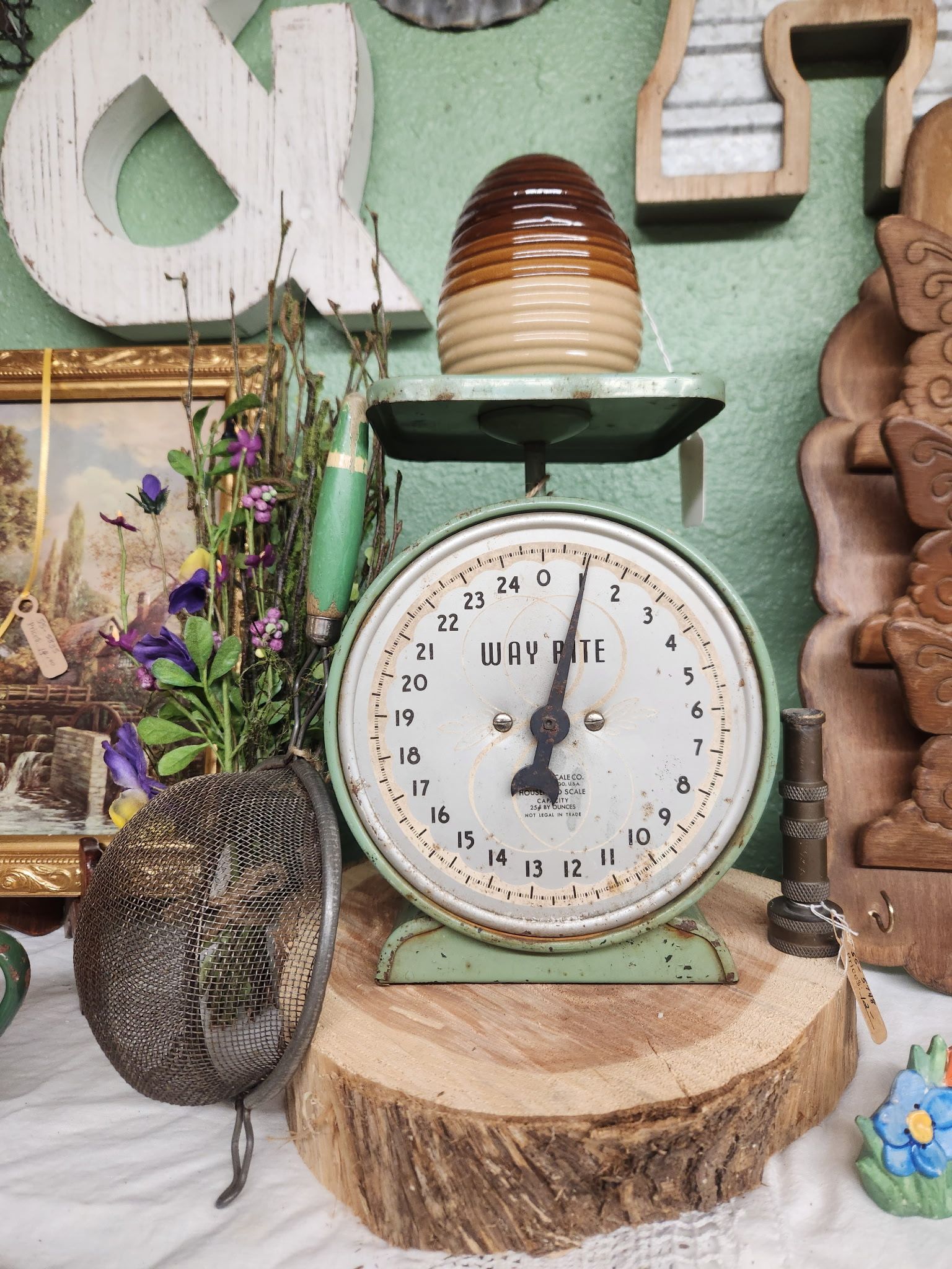 Vintage mint-green kitchen scale on a wood slice with flowers and rustic decor