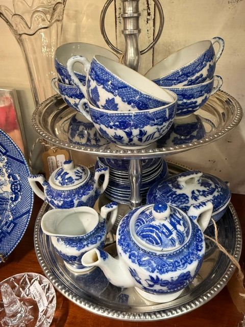 Blue-and-white ceramic tea set on a tiered silver stand with cups, teapot, and bowls