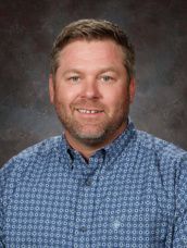 A man in a plaid shirt is smiling for a picture.