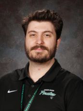 A man in a black shirt is posing for a picture in front of a green background.