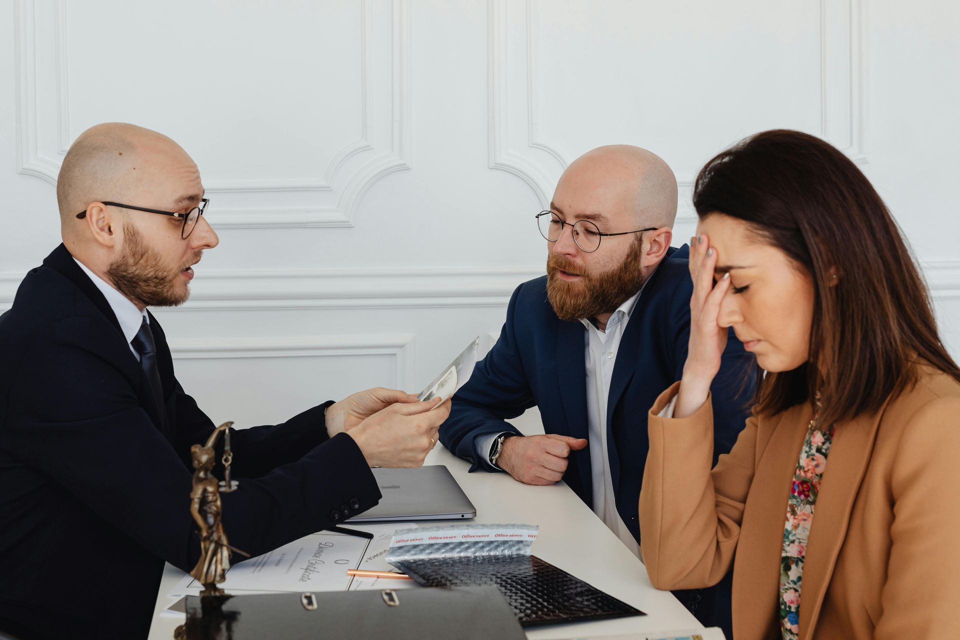 A man and a woman are sitting at a table talking to a lawyer.