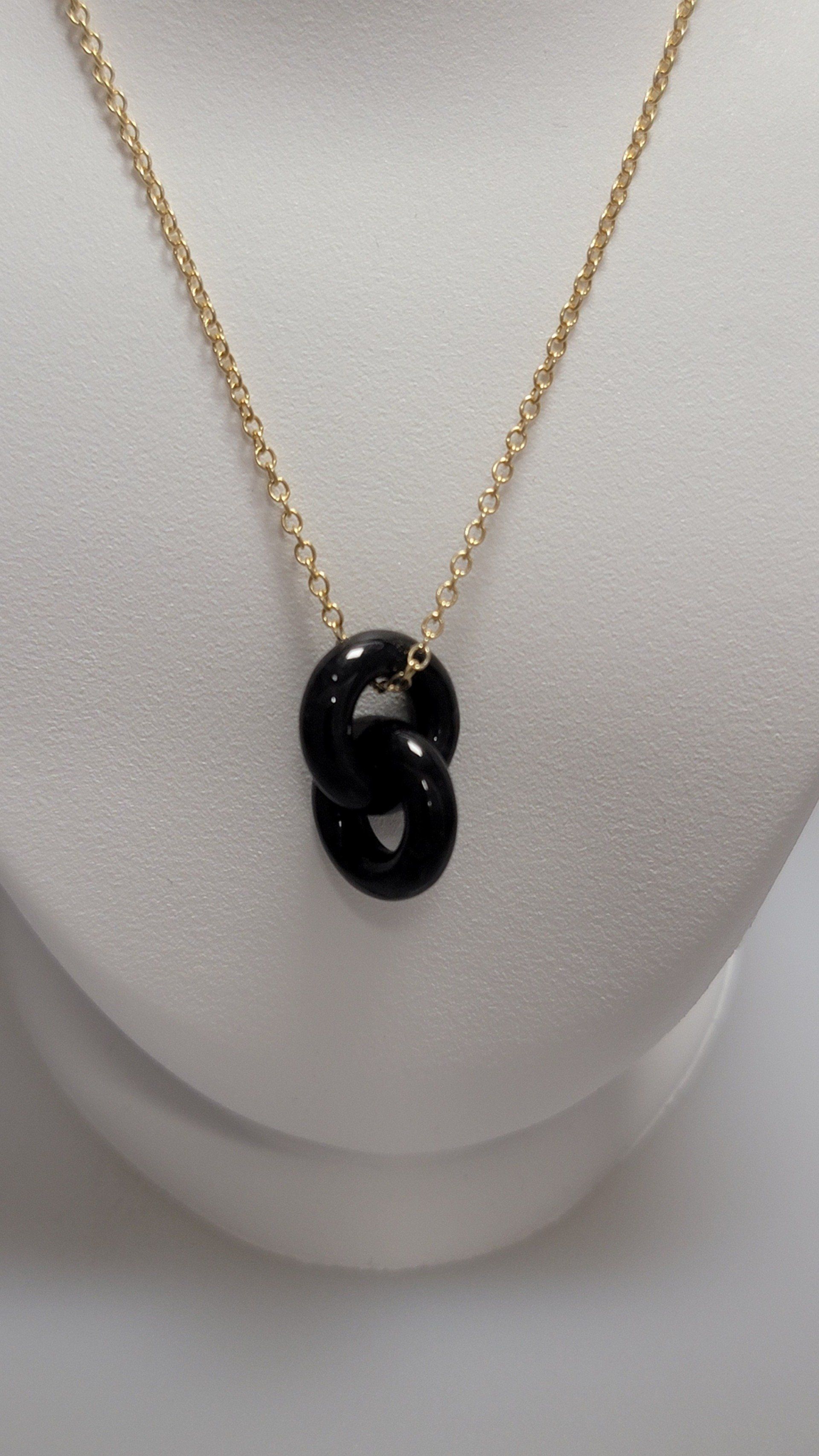 Gold chain necklace with interlocking black rings.