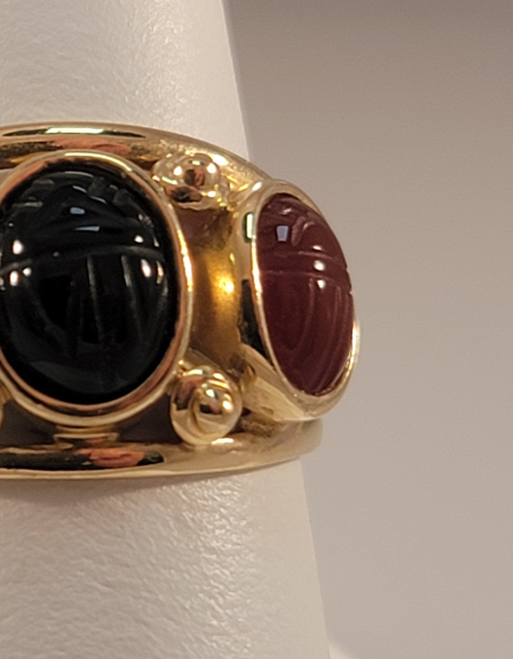 Gold ring with black and red carved scarab beetle stones.