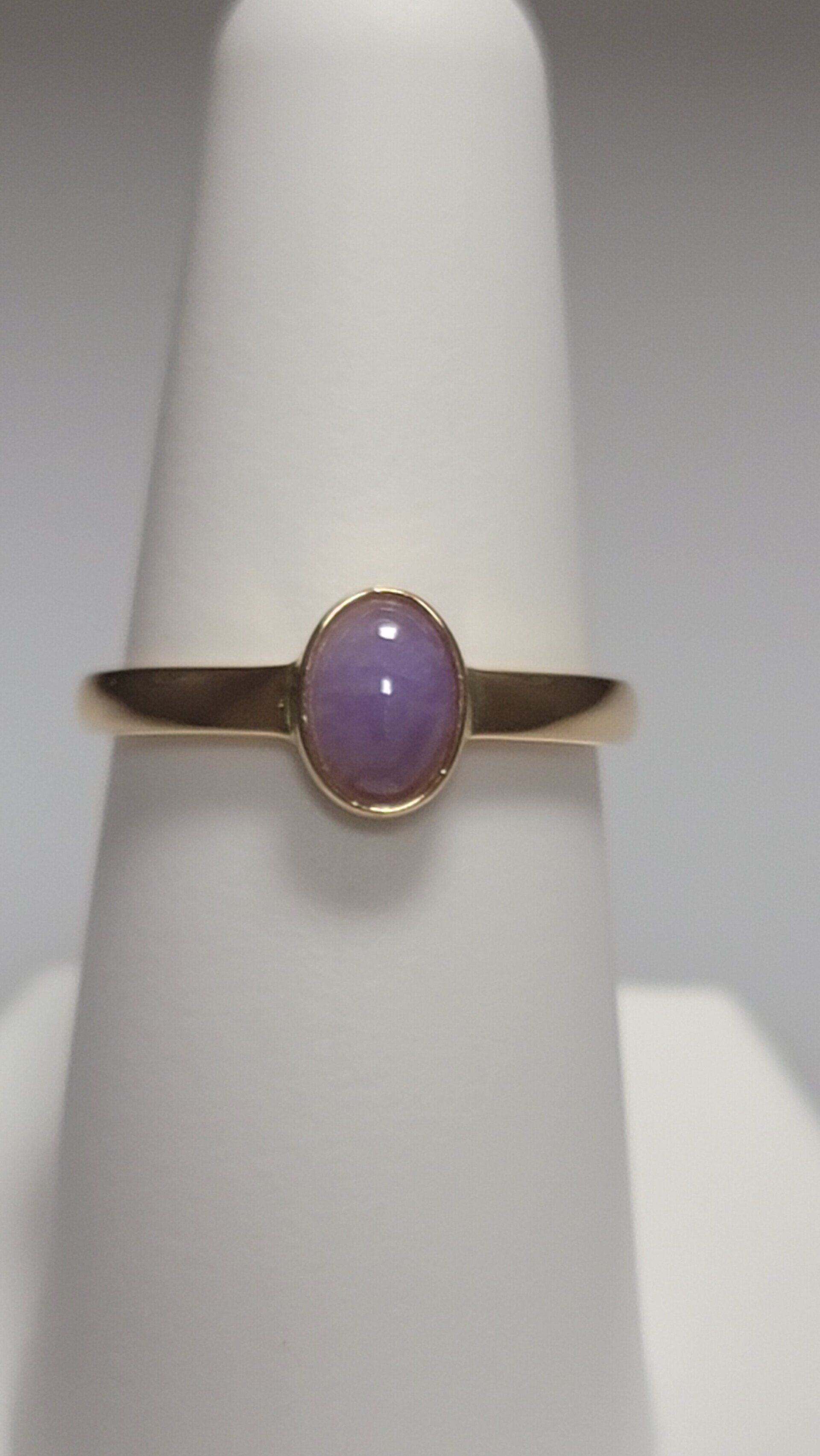 Gold ring with oval lavender gemstone.