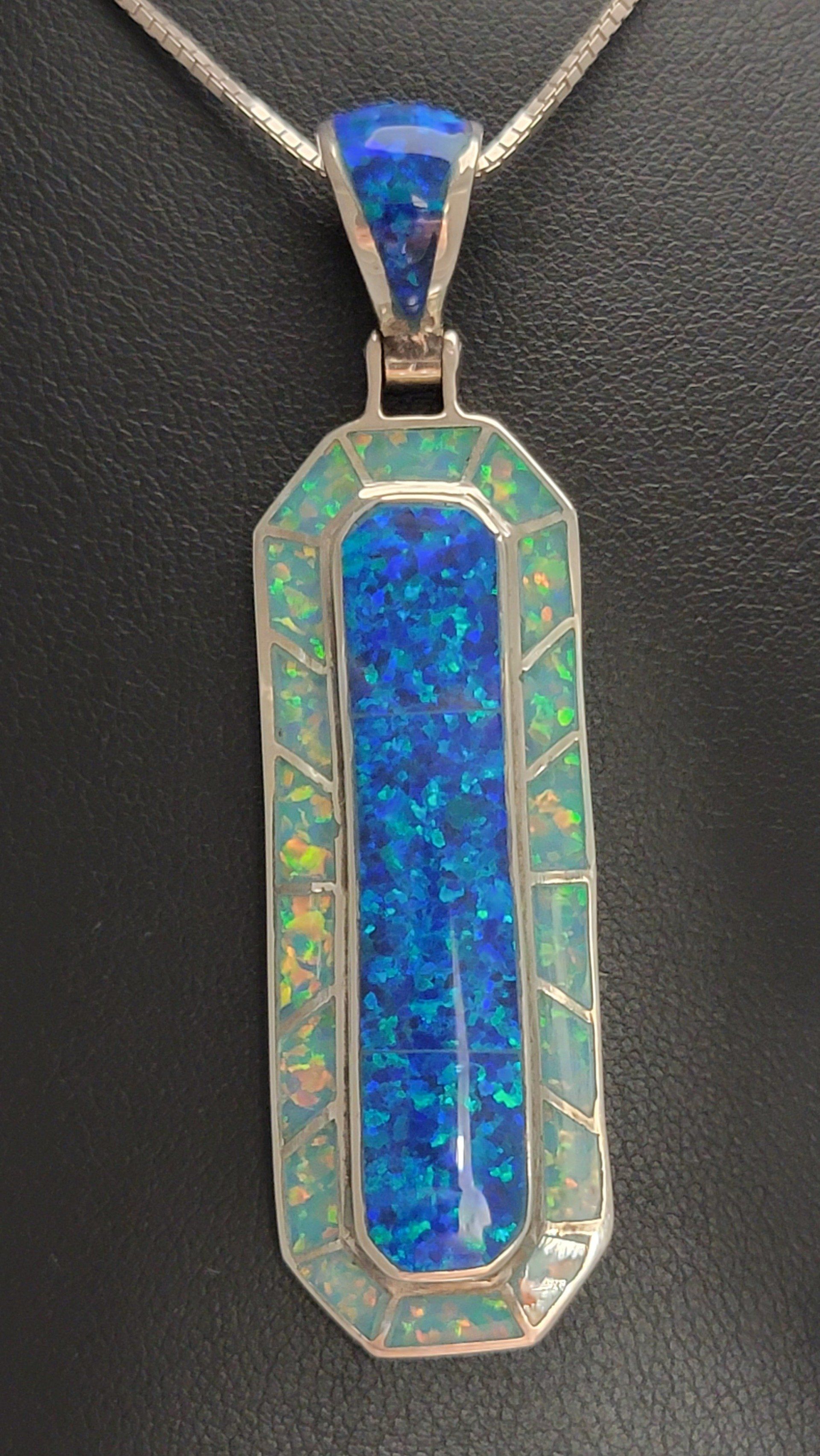 Blue opal pendant necklace on black backdrop.
