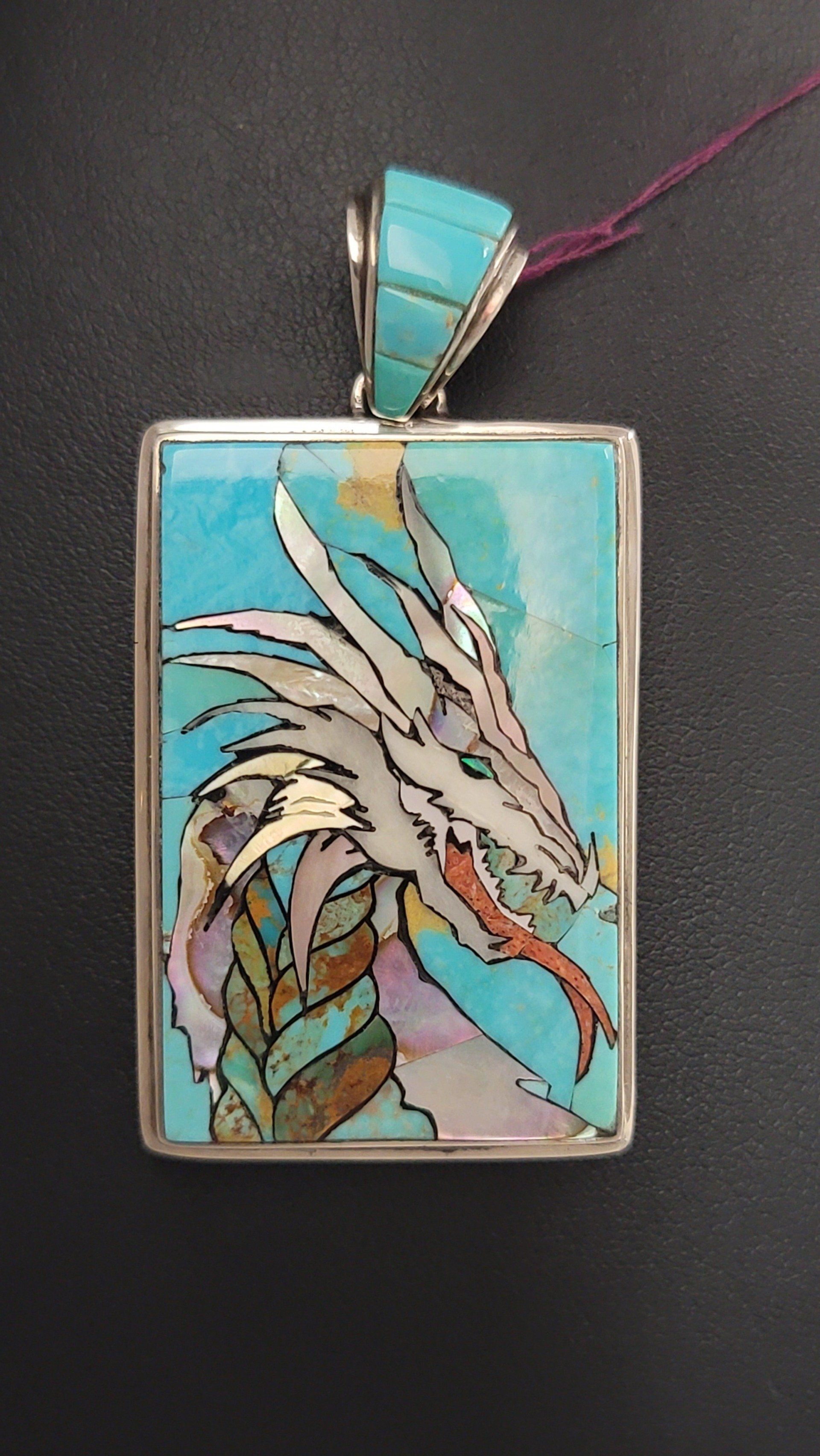 Turquoise pendant with a dragon mosaic inlaid in silver.