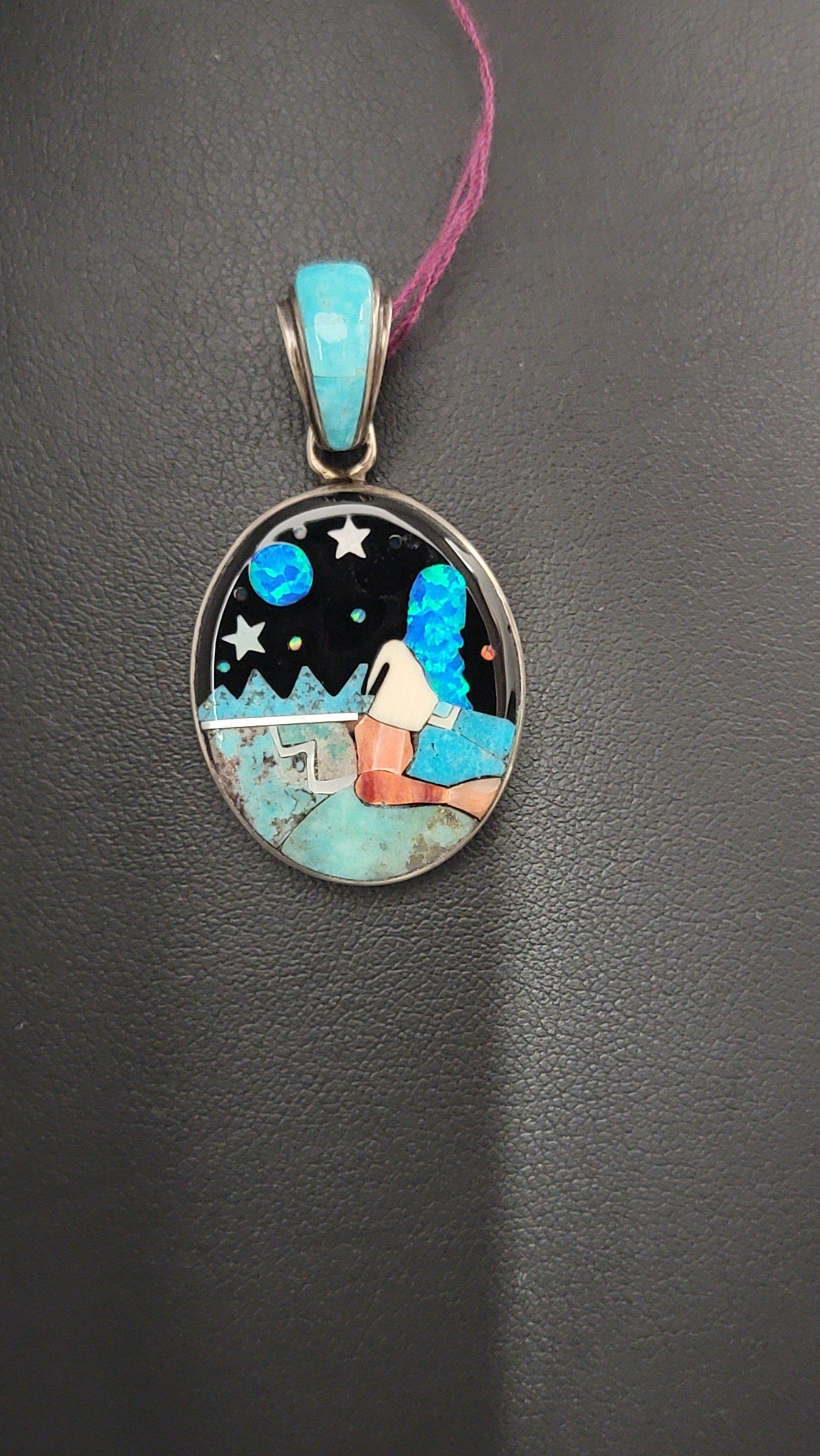 Pendant with mosaic-style night scene. Turquoise, black, and coral-colored elements in silver setting.