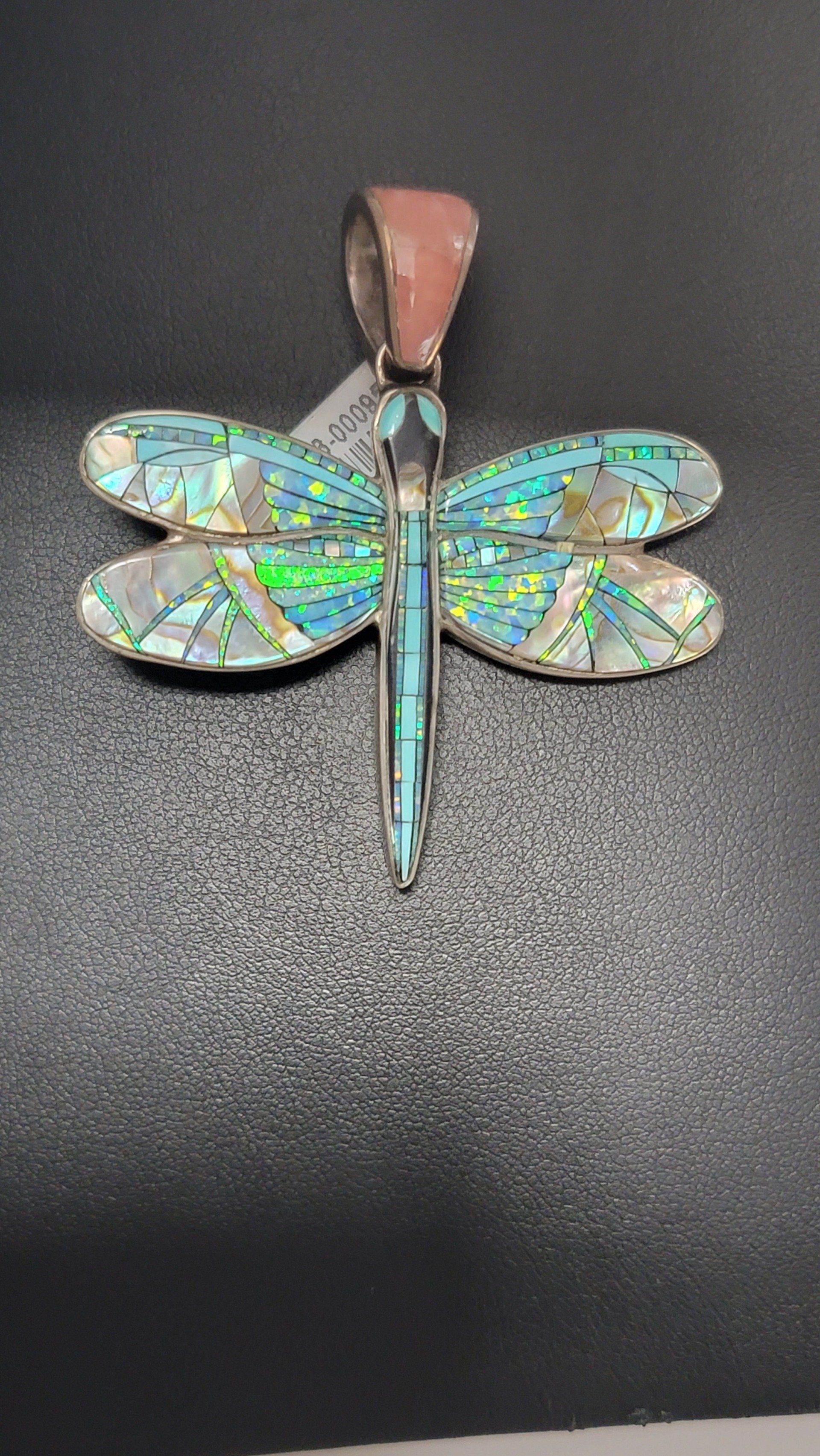Dragonfly pendant with iridescent blue and green inlay, silver metal, and pink top.