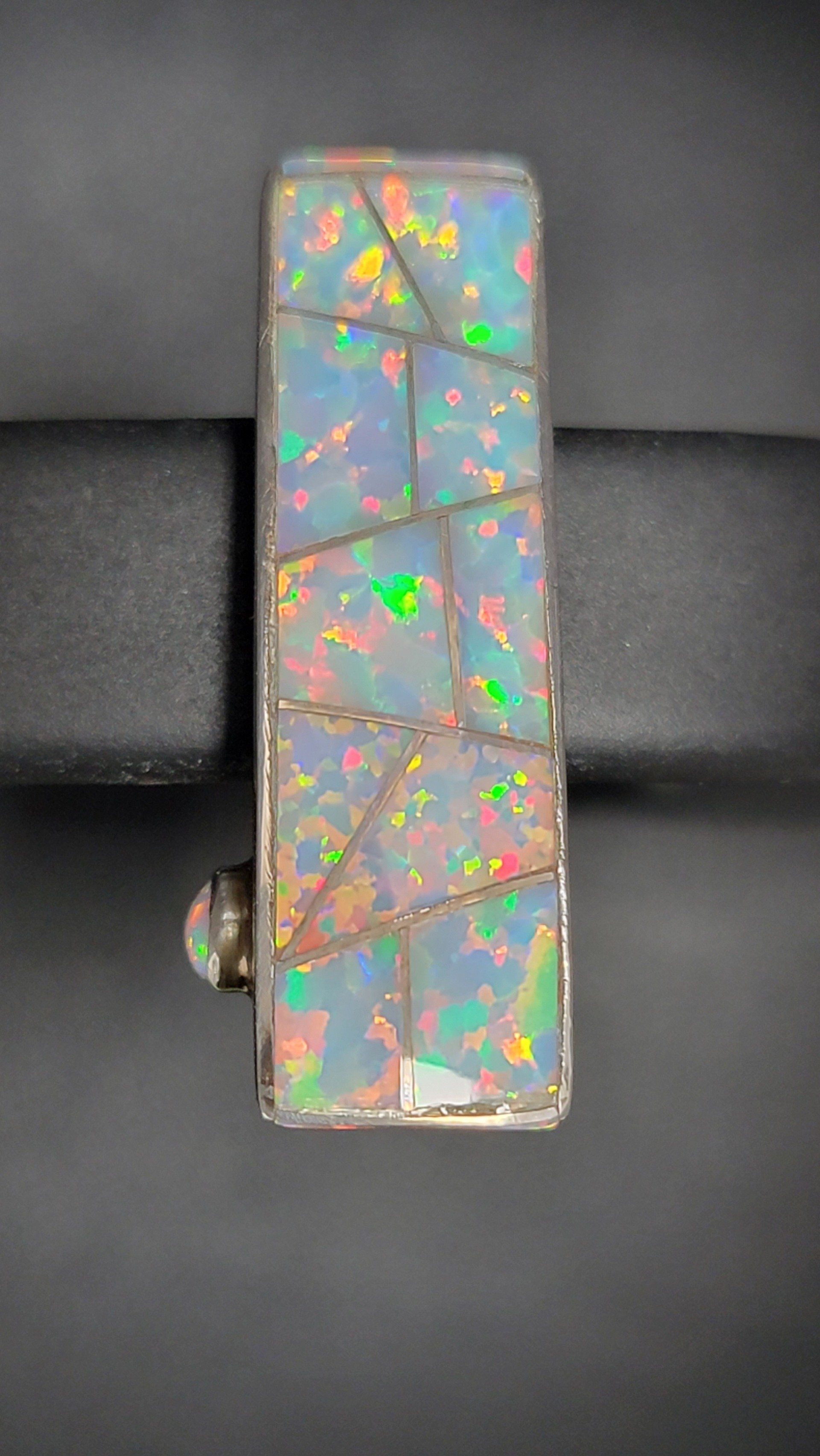 Rectangular opal pendant with multicolor iridescence, set in silver.