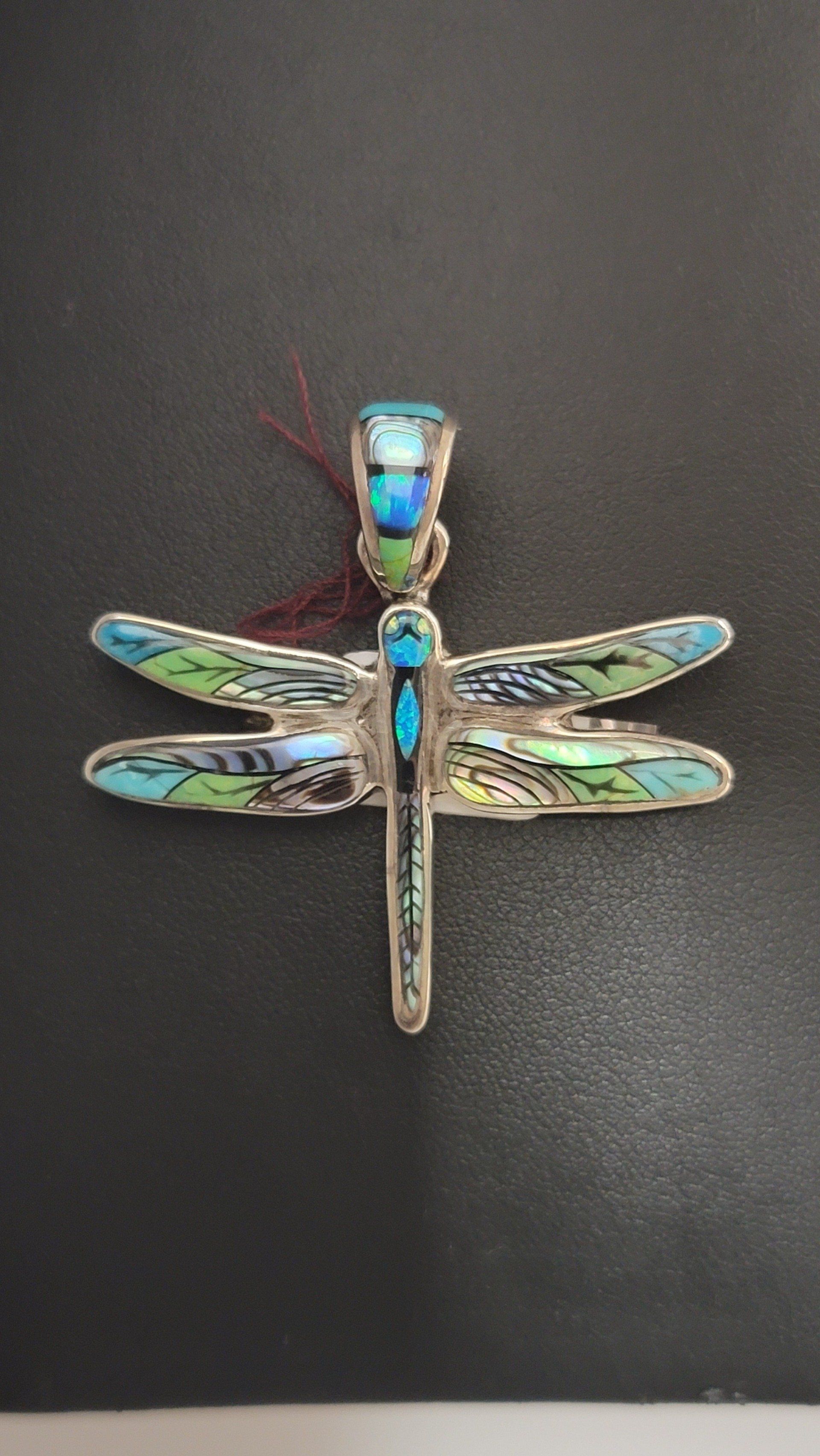 Silver dragonfly pendant with blue and green iridescent wings.