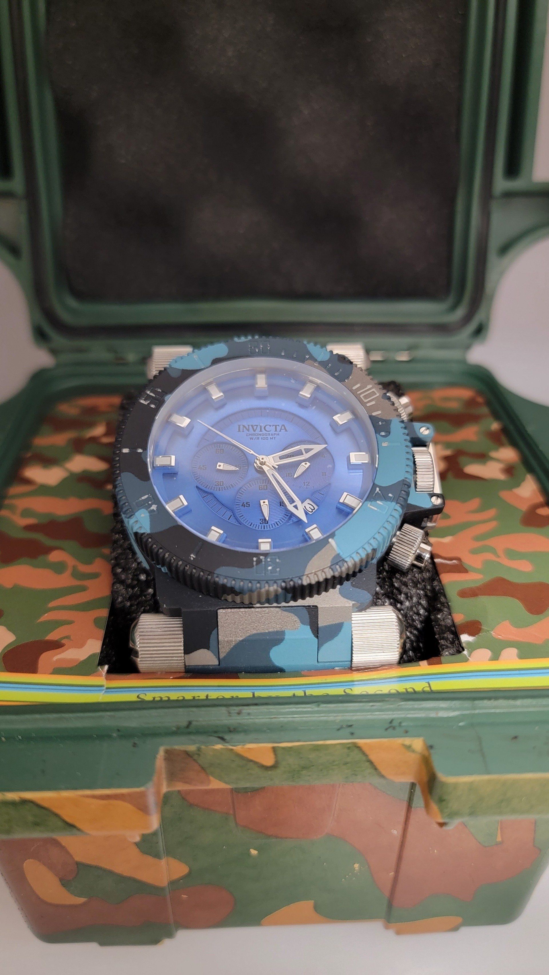 Watch with blue camo face and strap in a camo case.