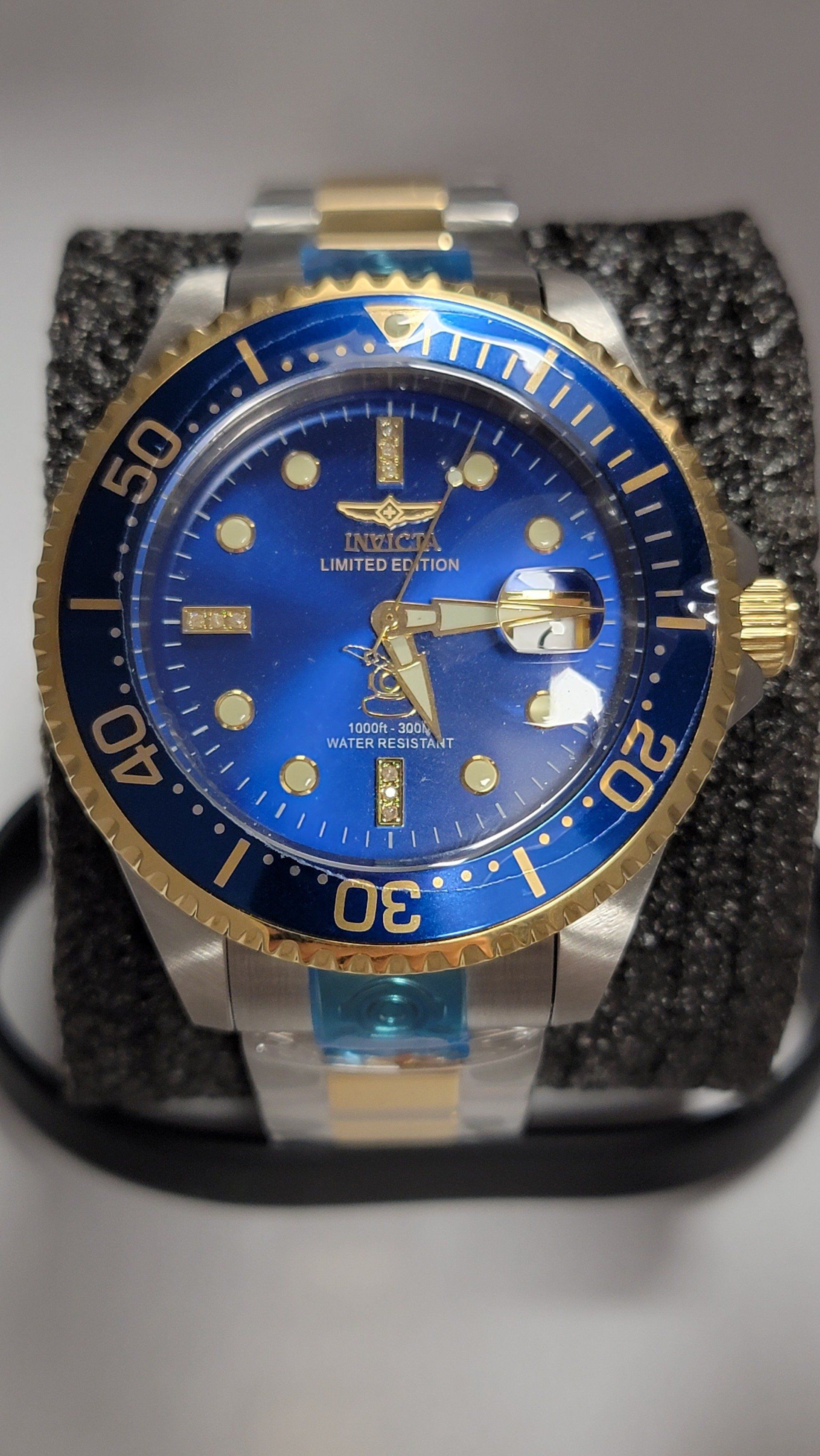 Invicta dive watch, gold bezel, blue face, gold and silver band.