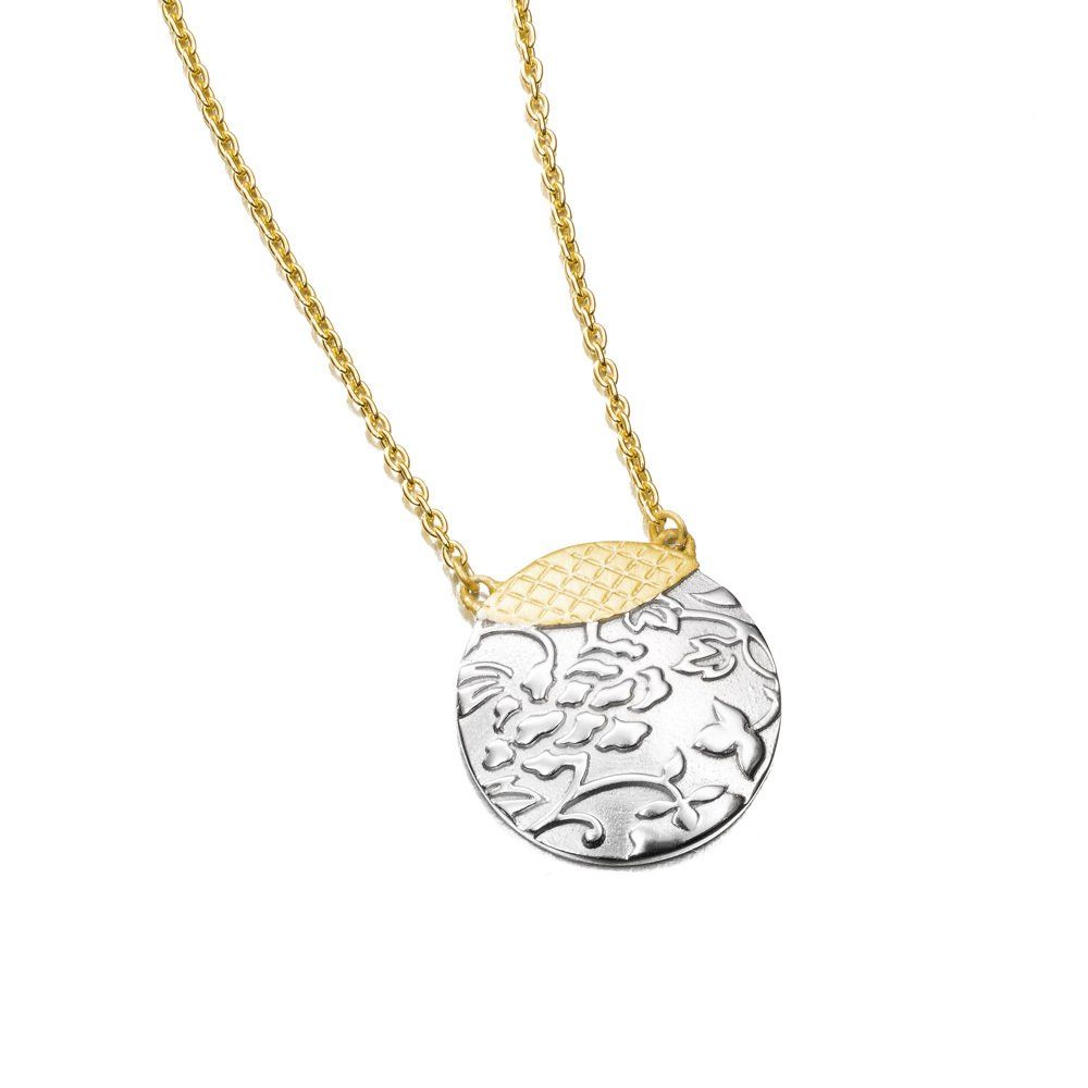 Gold chain necklace with a round silver pendant featuring embossed floral details.