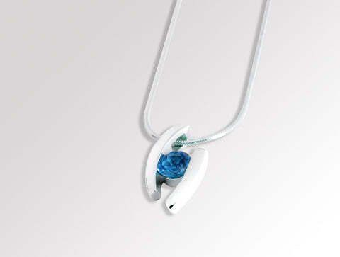 Silver pendant with a blue gemstone on a white background.