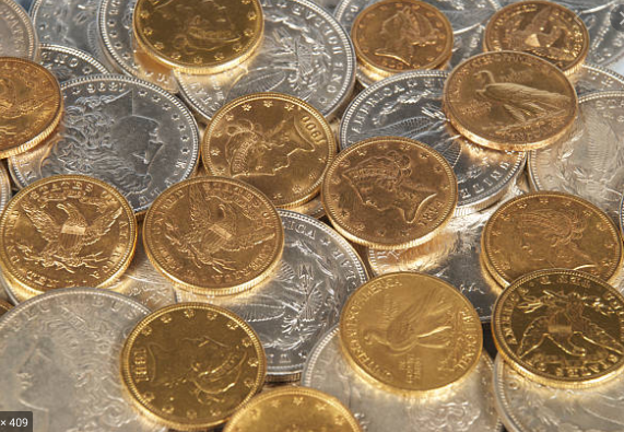 Gold and silver coins are scattered in a pile.