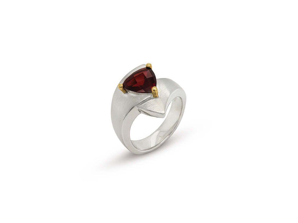 Silver ring with a triangular red gemstone set with gold accents.