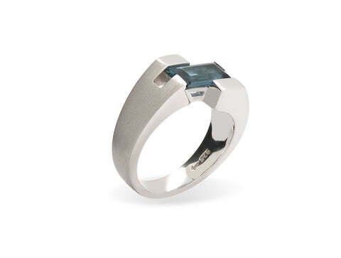 Silver ring with a rectangular blue gemstone.