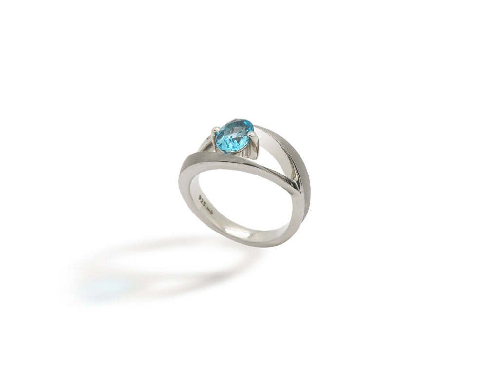 Silver ring with a blue oval gemstone.