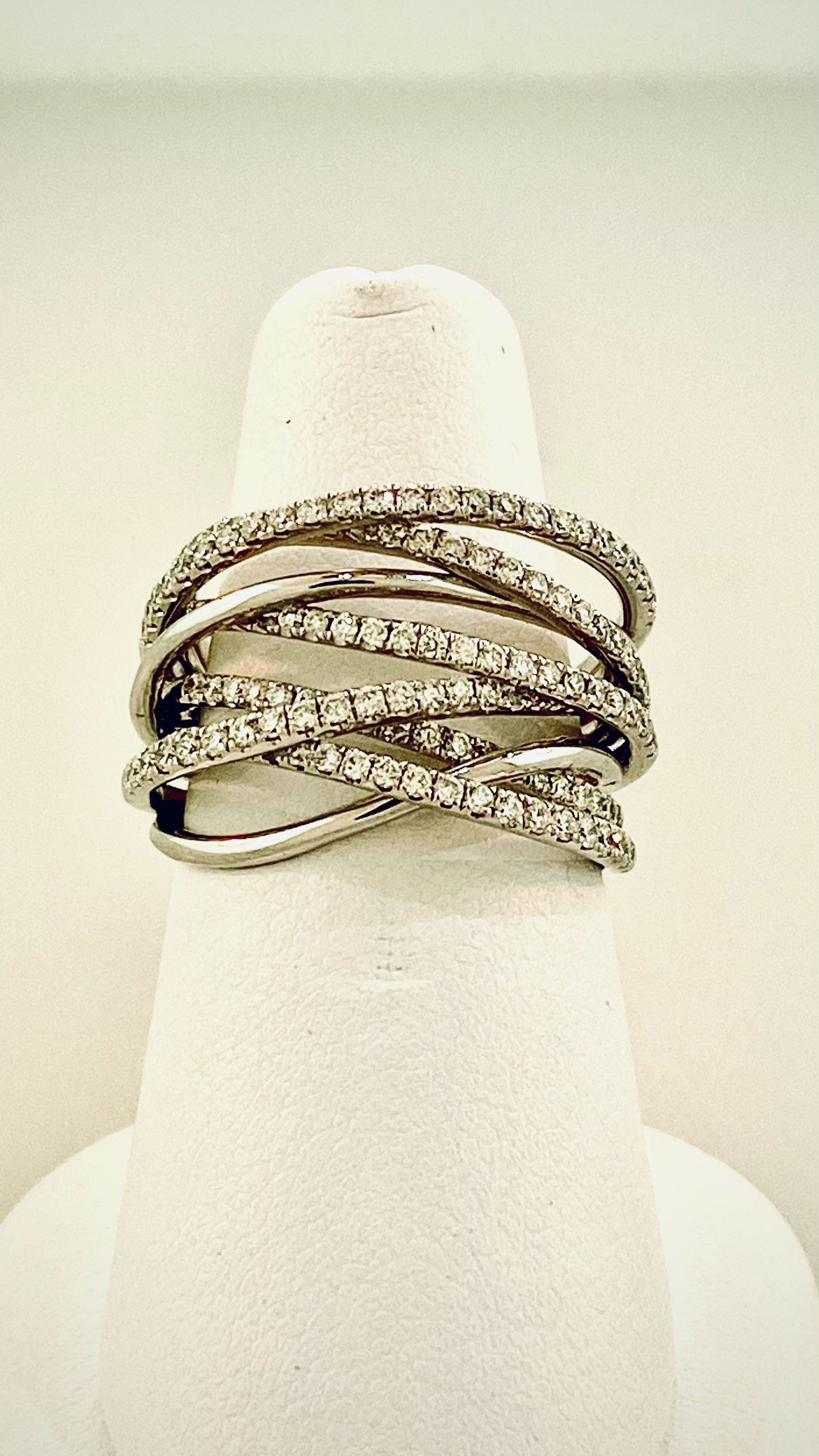 Diamond ring, multiple crisscrossing bands, displayed on a white finger form.