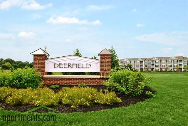 Deerfield apartment community entrance sign with landscaping and buildings in the background