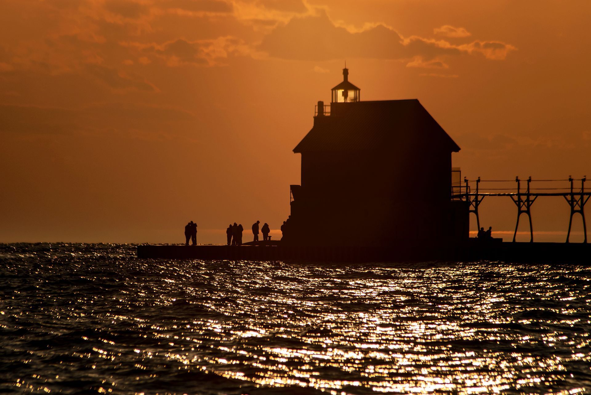A silhouette of a lighthouse in the middle of a body of water