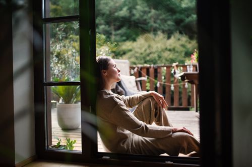 Woman resting peacefully in doorway, enjoying a quiet moment of self-care and relaxation Woman resting peacefully in doorway, enjoying a quiet moment of self-care and relaxation