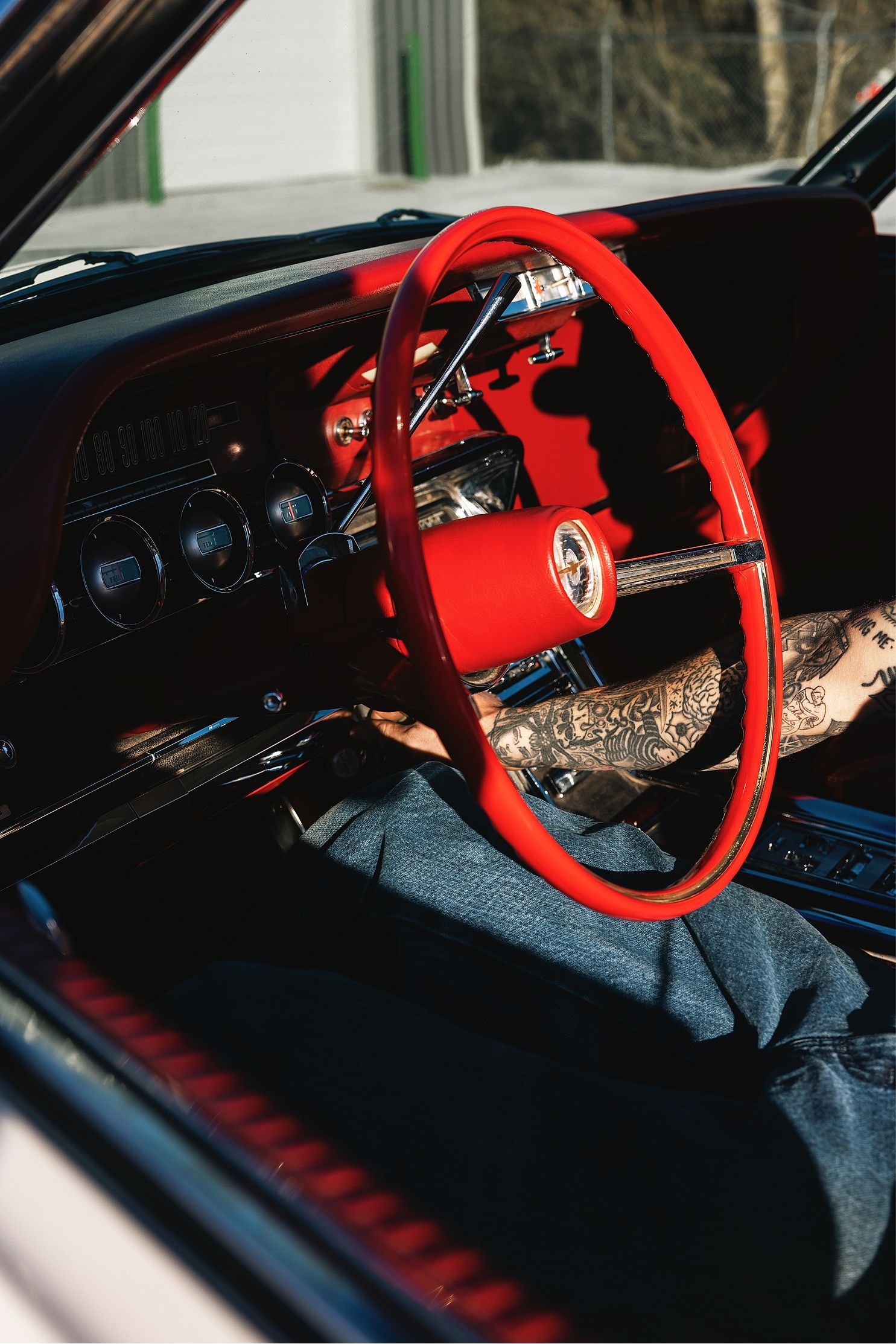 Red steering wheel inside classic car interior. | Gearhead Autoworks