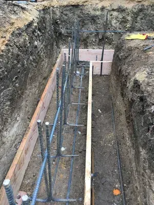 Deep trench with rebar and formwork for a concrete foundation under construction