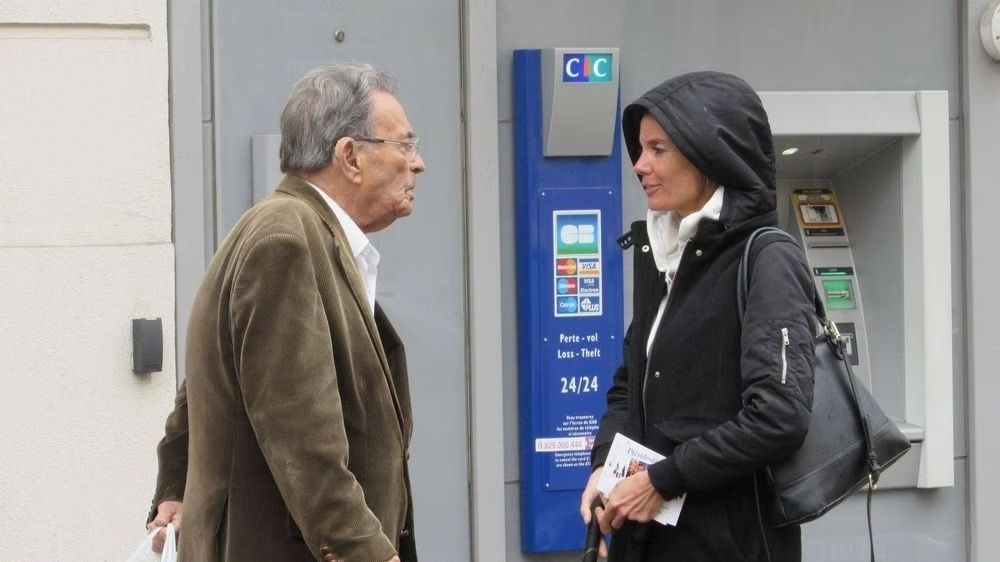 Un homme et une femme discutent devant un distributeur automatique