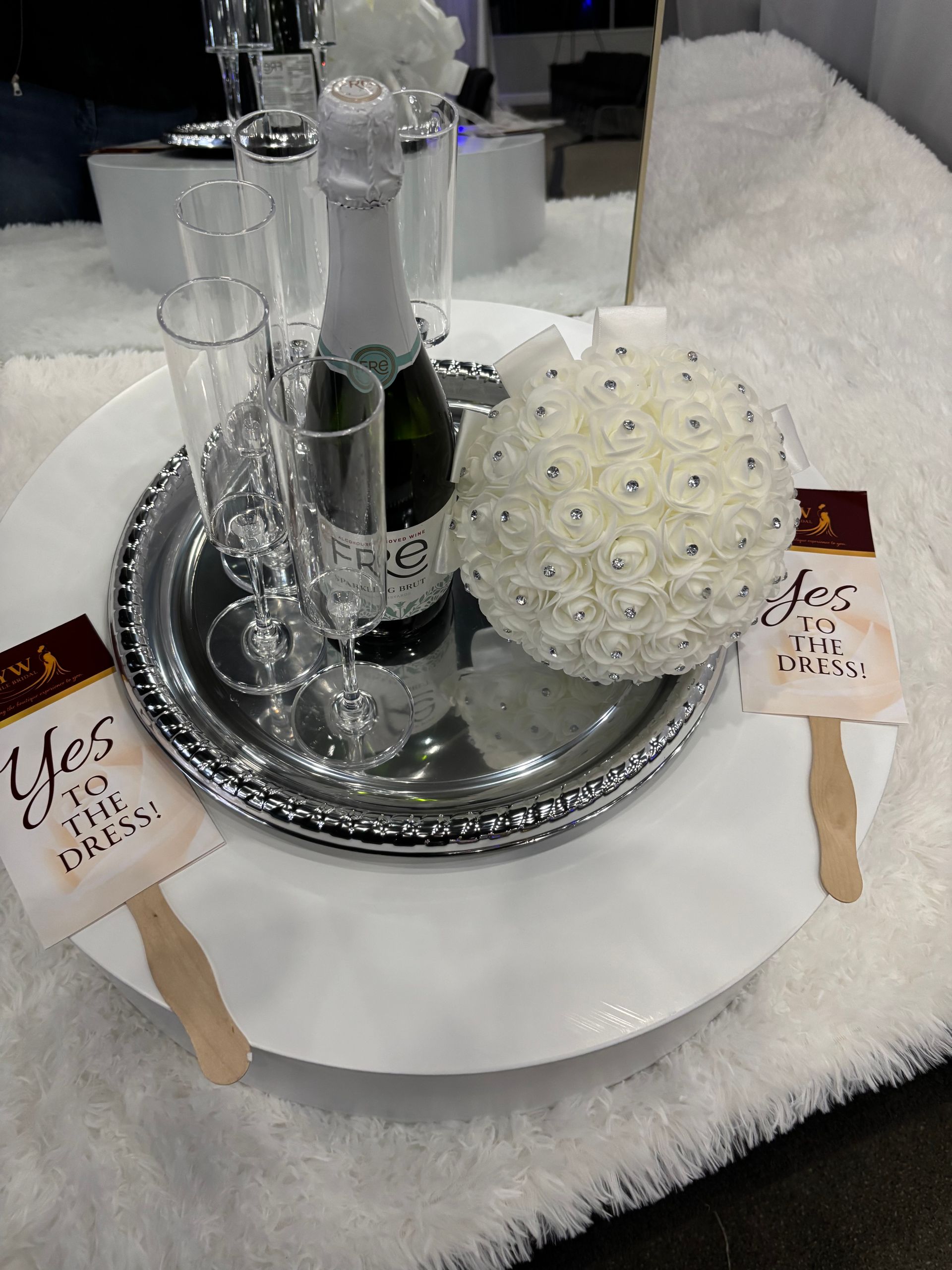 White lace wedding table centerpiece with silver tray, candles, and two small wooden favor signs.