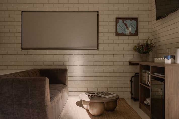 Cozy bedroom with a large bed, brick accent wall, and two glowing bedside lamps.