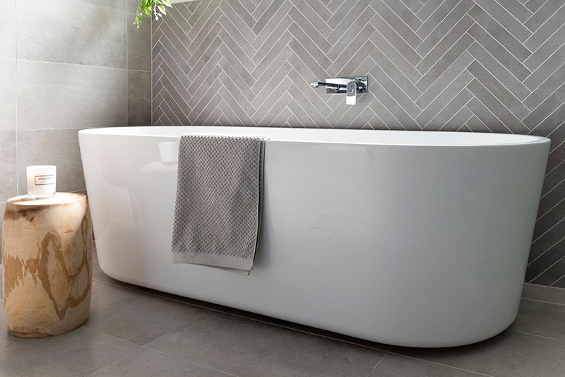 A bathroom with a bathtub and a wooden stool.