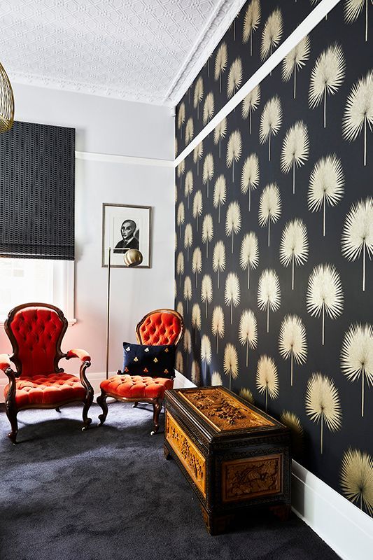 A living room with a black wall with white trees on it
