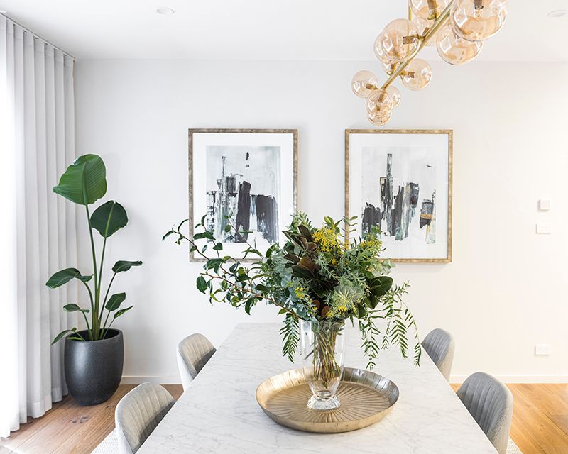 There is a vase of flowers on the table in the dining room.