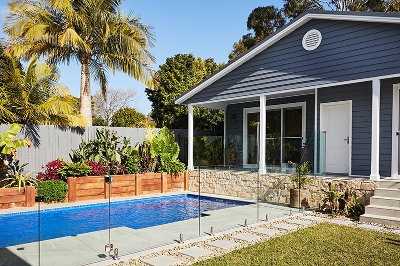A house with a swimming pool in front of it.