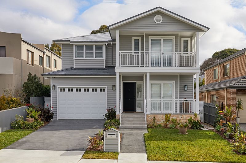 A large house with a white garage door is sitting on top of a lush green lawn.