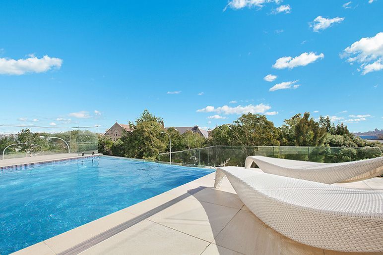 A swimming pool with a lot of chairs around it.