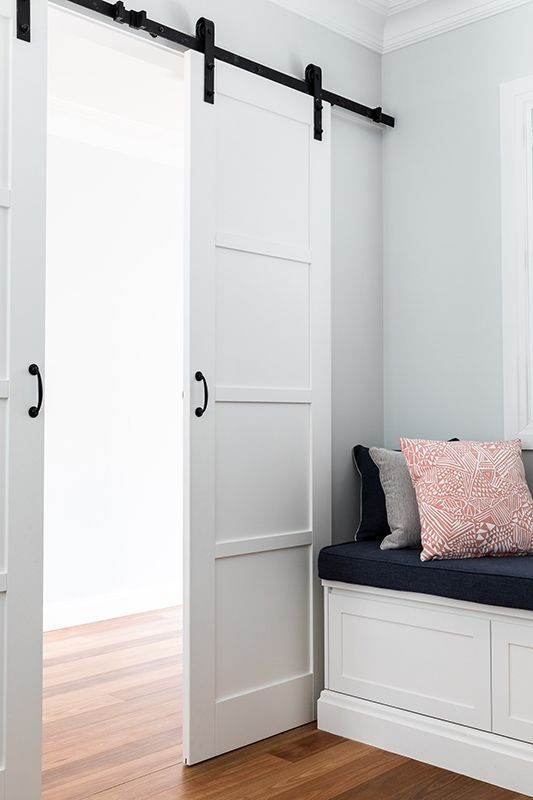 A bedroom with a sliding barn door and a bench.